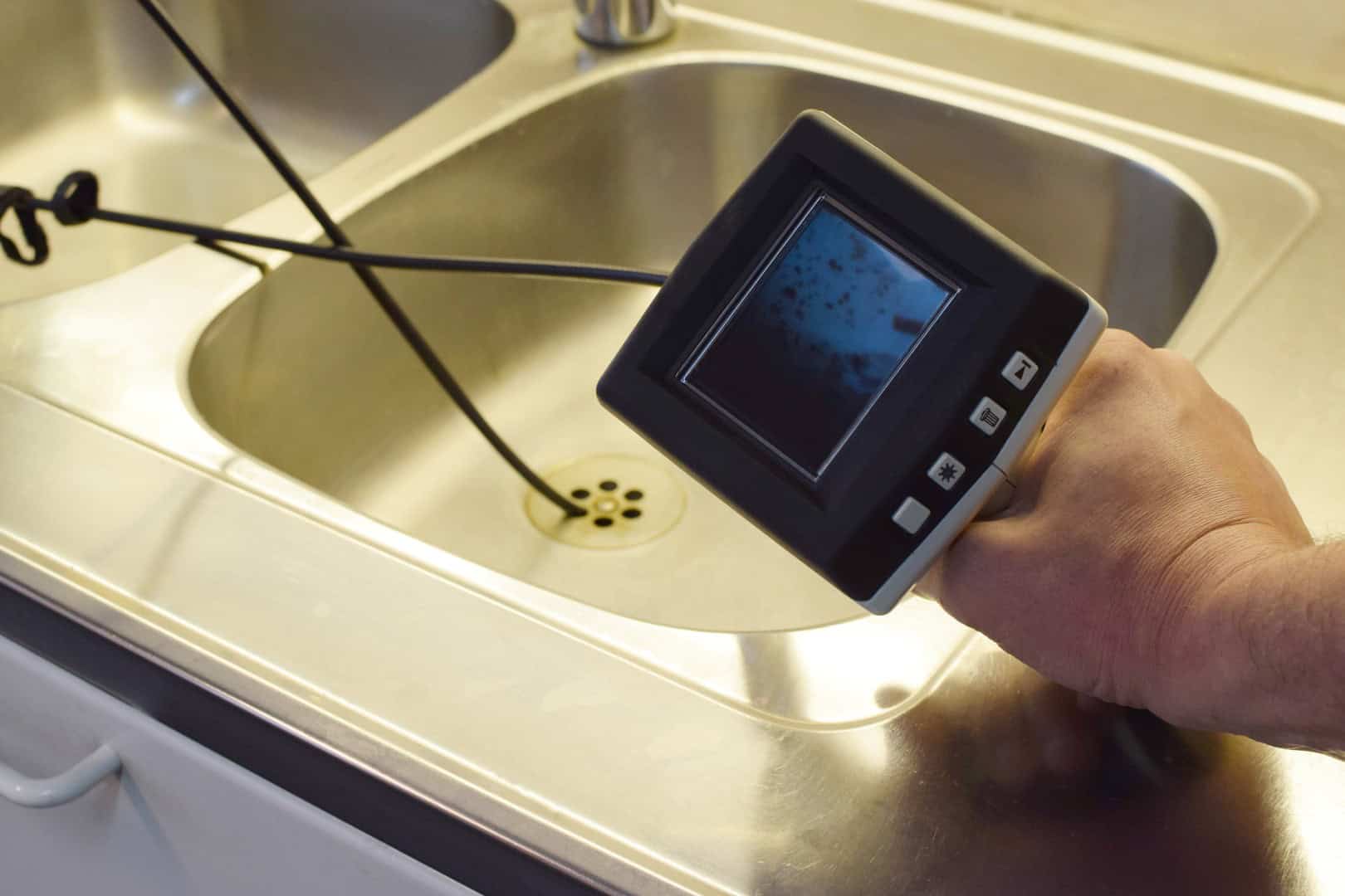 Checking drain pipe with borescope inspection camera.